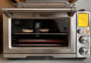 New stainless steel replacement rack sliding into the guide rails of a Breville Smart Oven Pro BOV900BSS