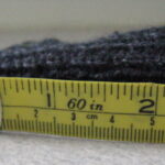 Measuring knit gauge using a tape measure.