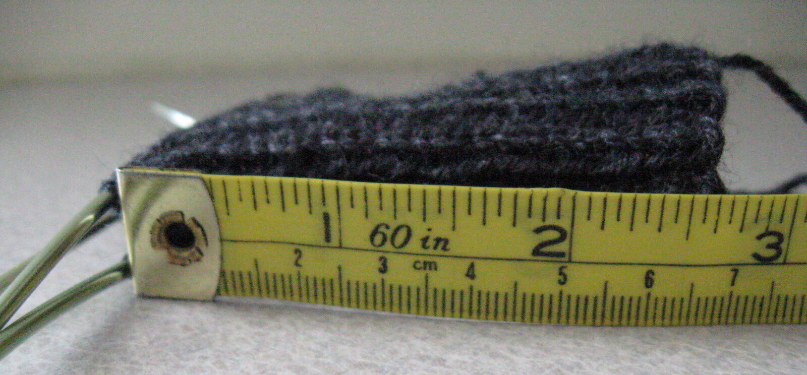 Measuring knit gauge using a tape measure.